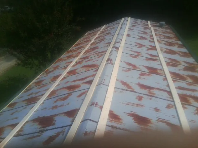 Rusted metal roof panels with new wood purlins before replacement — Storm Damage Roof Repair in Seminole by Roofing Brothers