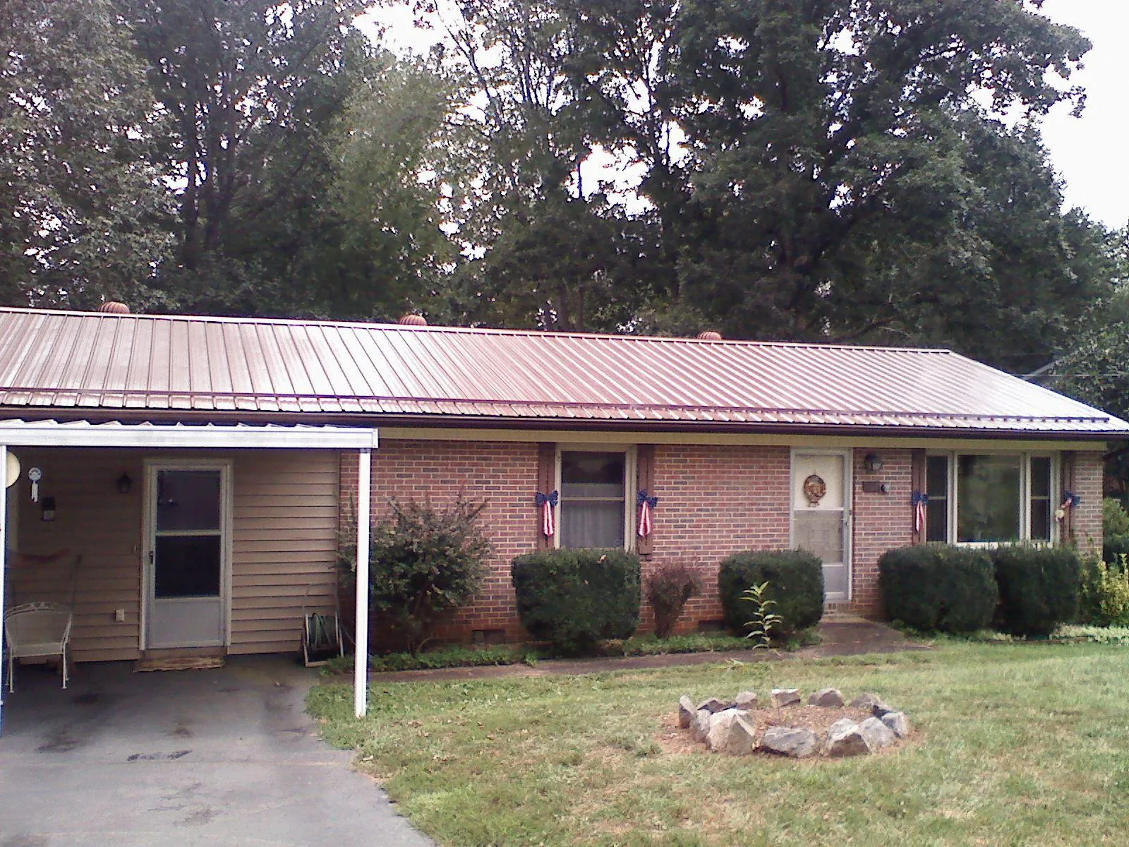 Bronze metal roof and carport on a brick ranch home — Roof Repair work by our crew in Seminole