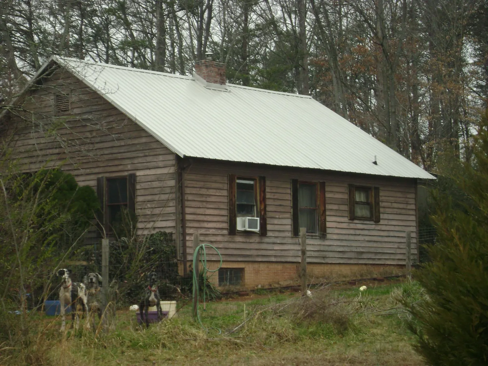 White metal roof on an old wood sided farmhouse, from a Metal Roof Installation job in Seminole